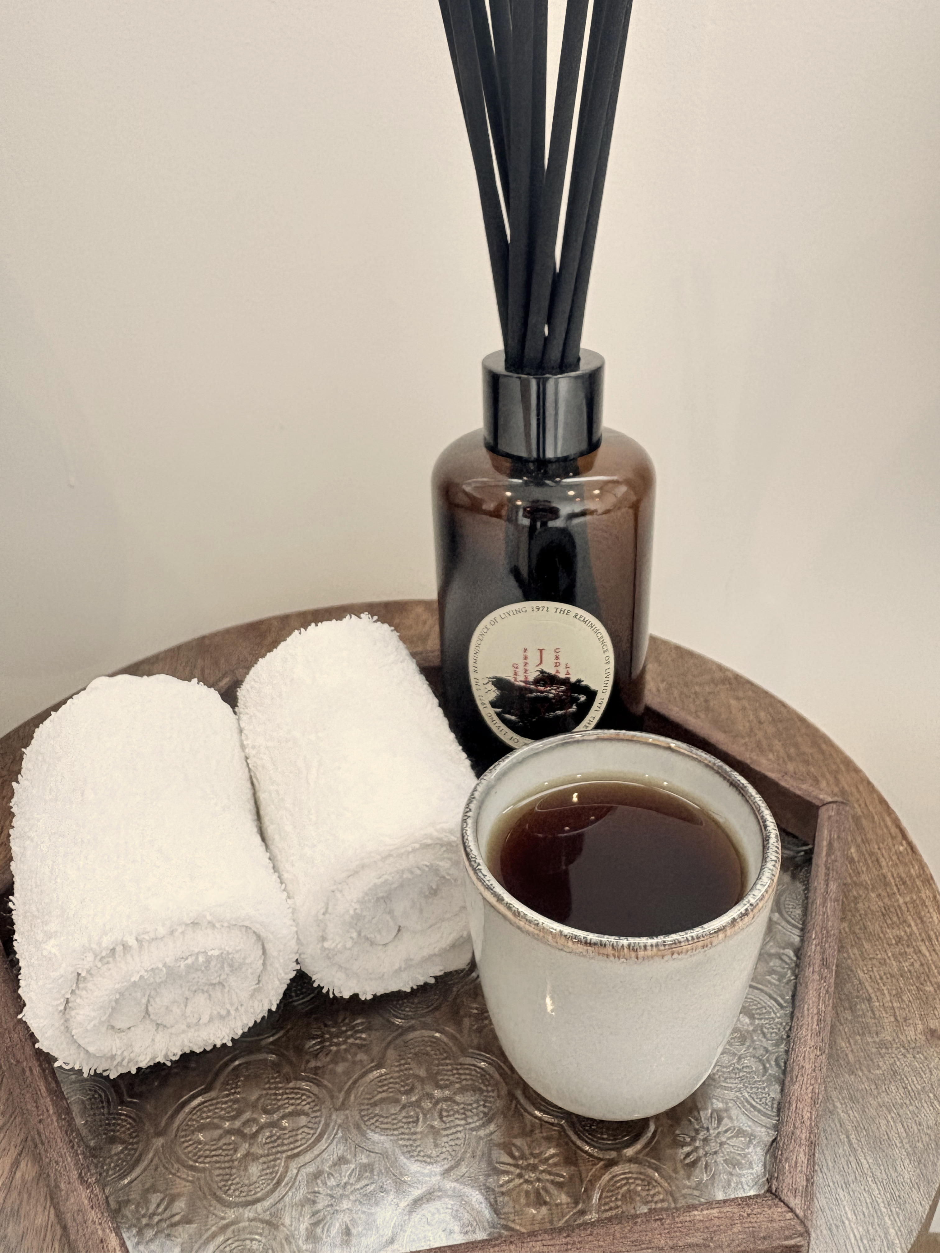 Herbal tea and rolled towels on a wooden tray at Siam Soul
