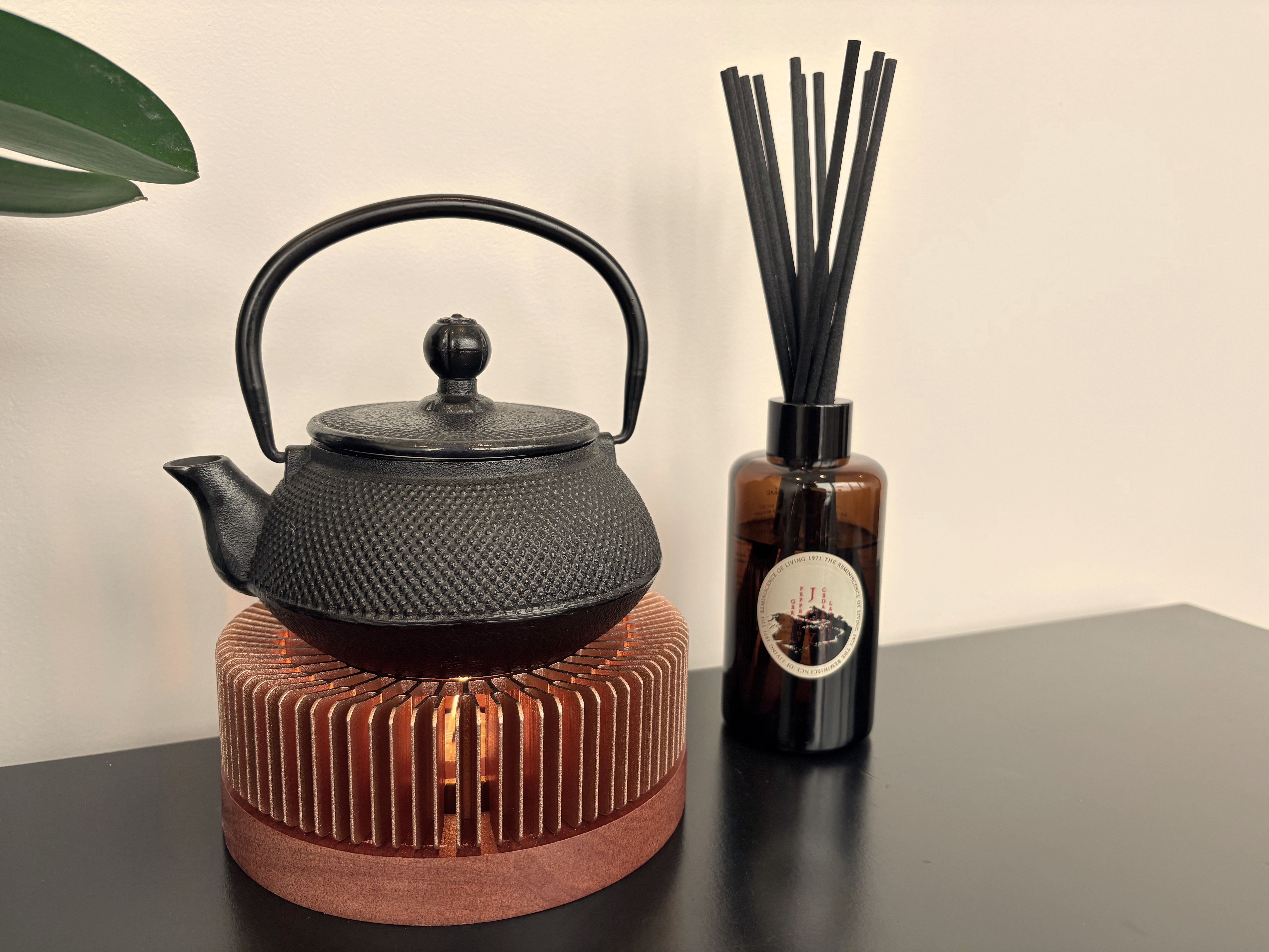 Iron teapot on bamboo candle warmer with amber reed diffuser